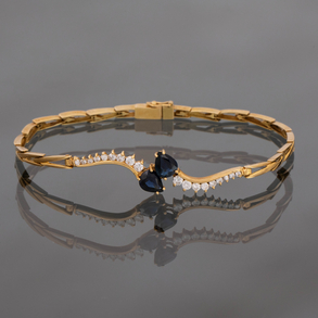 Pulsera en oro amarillo de 18kt y brillantes con dos zafiros talla pera.