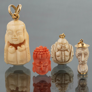 Conjunto de tres colgantes en hueso y coral con montura en oro amarillo de 18 kt.