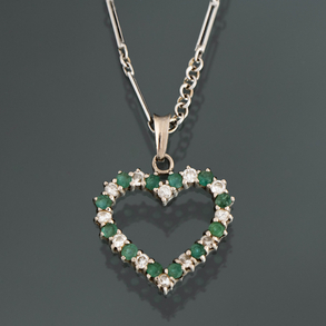 Cadena de oro blanco de 18kt con colgante en forma de corazón con brillantes y esmeralda.