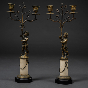 Pareja de candelabros de dos luces en bronce dorado con niños como tenantes y plinto circular en mármol blanco con base circular en mármol negro del siglo XIX