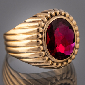 Anillo en oro amarillo de 18 kt con piedra de color rojo.