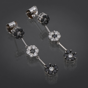 Pareja de pendientes largos en oro blanco de 18 kt con rosetones en forma de flor con brillantes y zafiros.