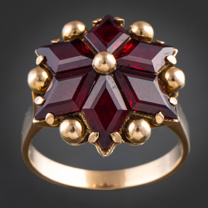 Sortija en forma de estrella de seis puntas en oro amarillo de 18 kt y granates.