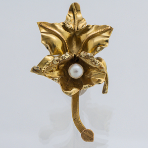 Broche en forma de flor en oro amarillo de 18 ky con perla.