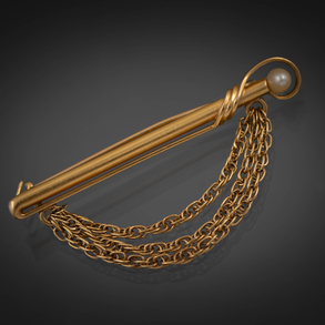 Alfiler de oro amarillo de 18 kt con perlita y tres cadenas a modo de congaduras.