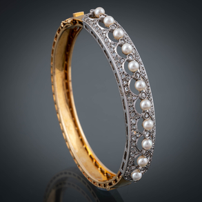 Brazalete rígido con abertura en oro amarillo de 18 kt con brillantes talla antigua y perlas.