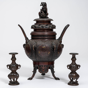 Quemador de incienso trípode  en bronce con toques de dorado periodo Meiji(1868-1912) tapa rematada con león de Foo y pareja de candeleros en bronce con patina marrón.